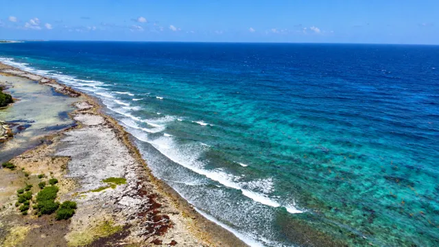 Turquoise reef and breaking waves along the island coast